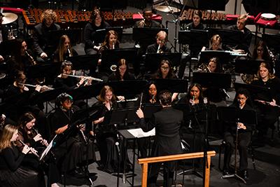 学生 playing instruments with conductor.